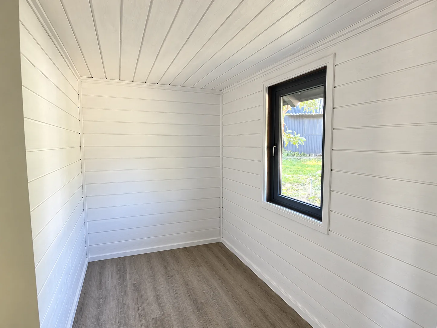01-dormitorio-blanco Dormitorio con muros blancos y ventana hacia el jardín