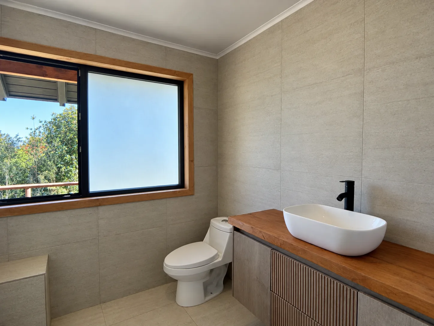 05-bano Baño con lavamanos sobre cubierta de madera y ventana al jardín