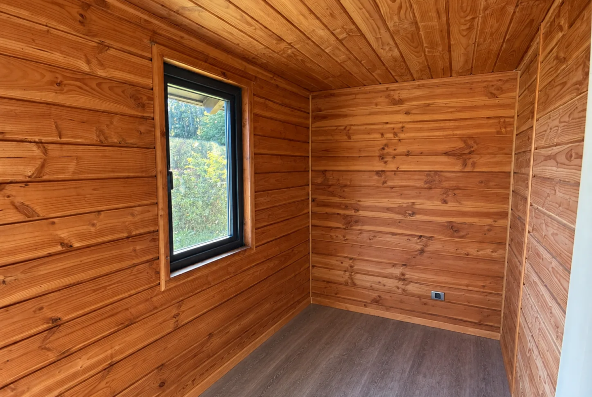 Recinto revestido en madera nativa con ventana