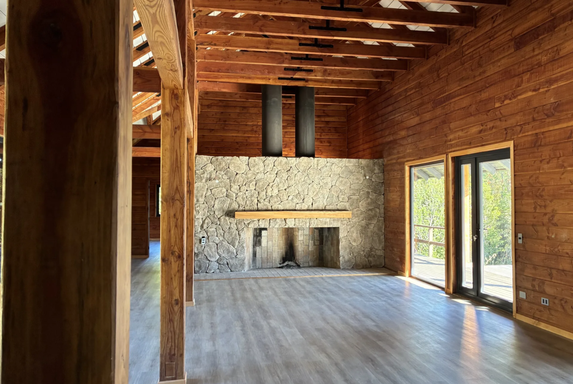 Living con chimenea, revestido en madera nativa