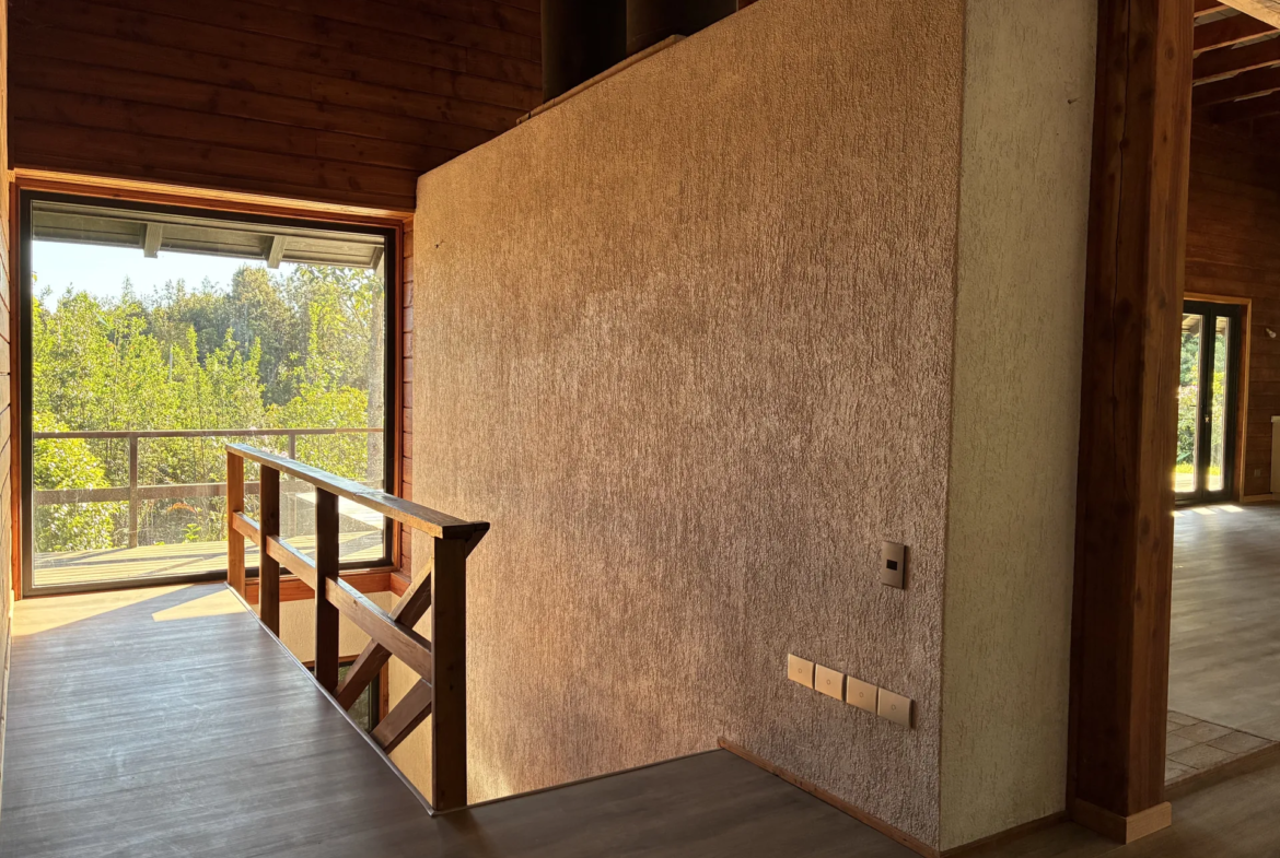 Escalera con baranda de madera y ventanal hacia el bosque