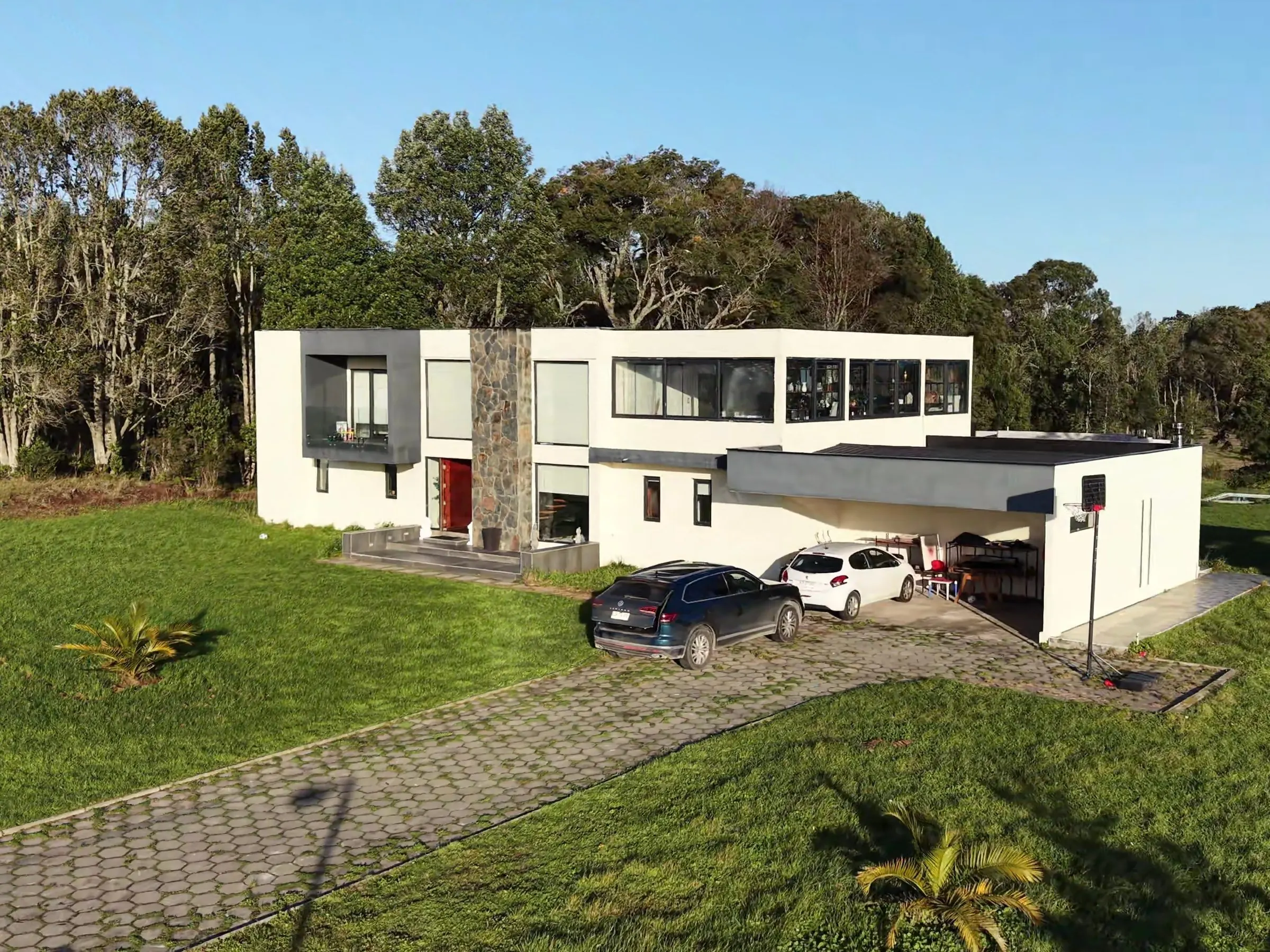 Casa de dos pisos con estacionamiento techado y acceso adoquinado, vista lateral Casa de dos pisos con estacionamiento techado y acceso adoquinado, vista lateral